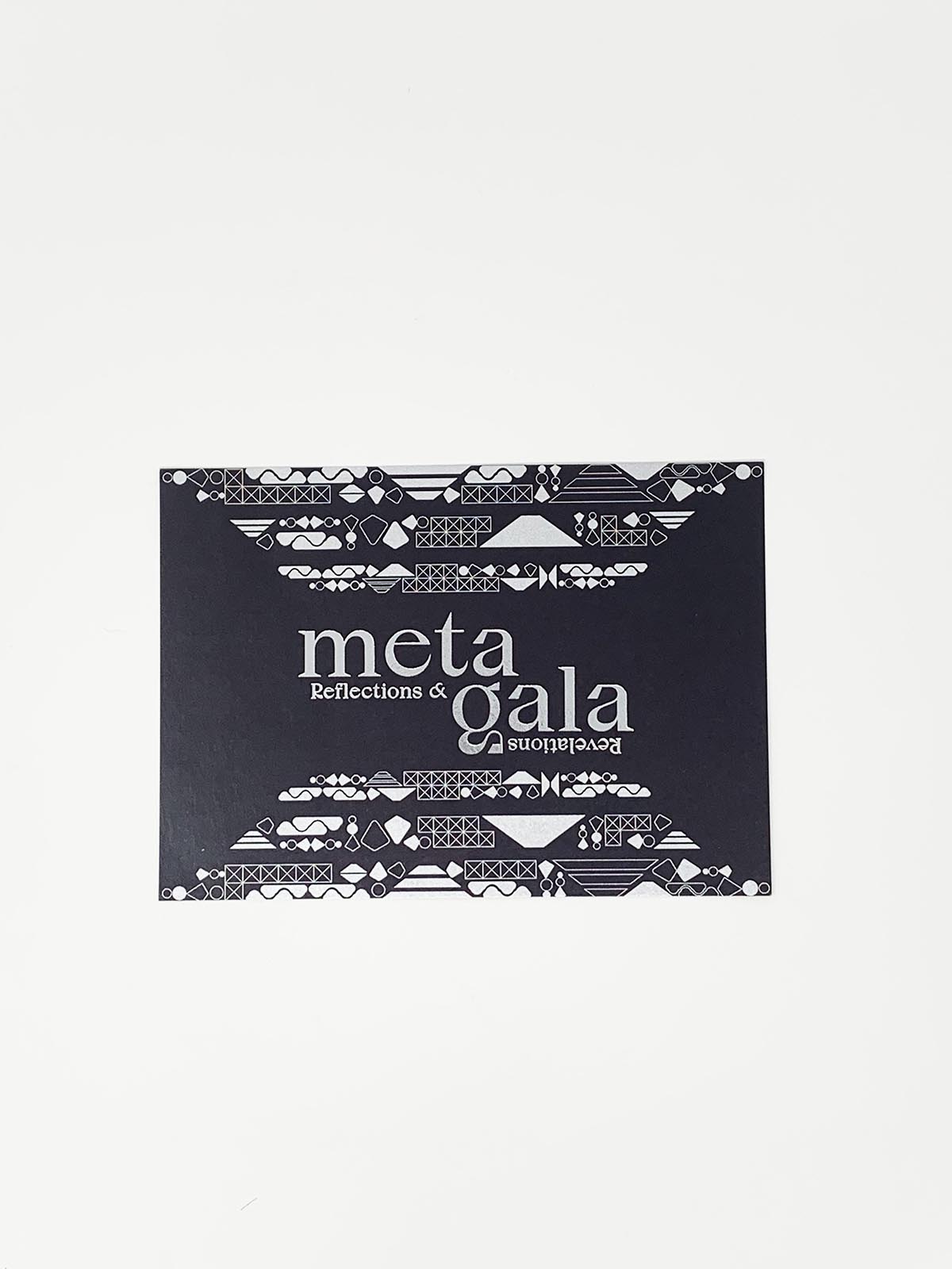 Close up of meta gala black design, says 'reflections & revelations' (with revelations reflected upside down) in small type along with large 'meta gala'.